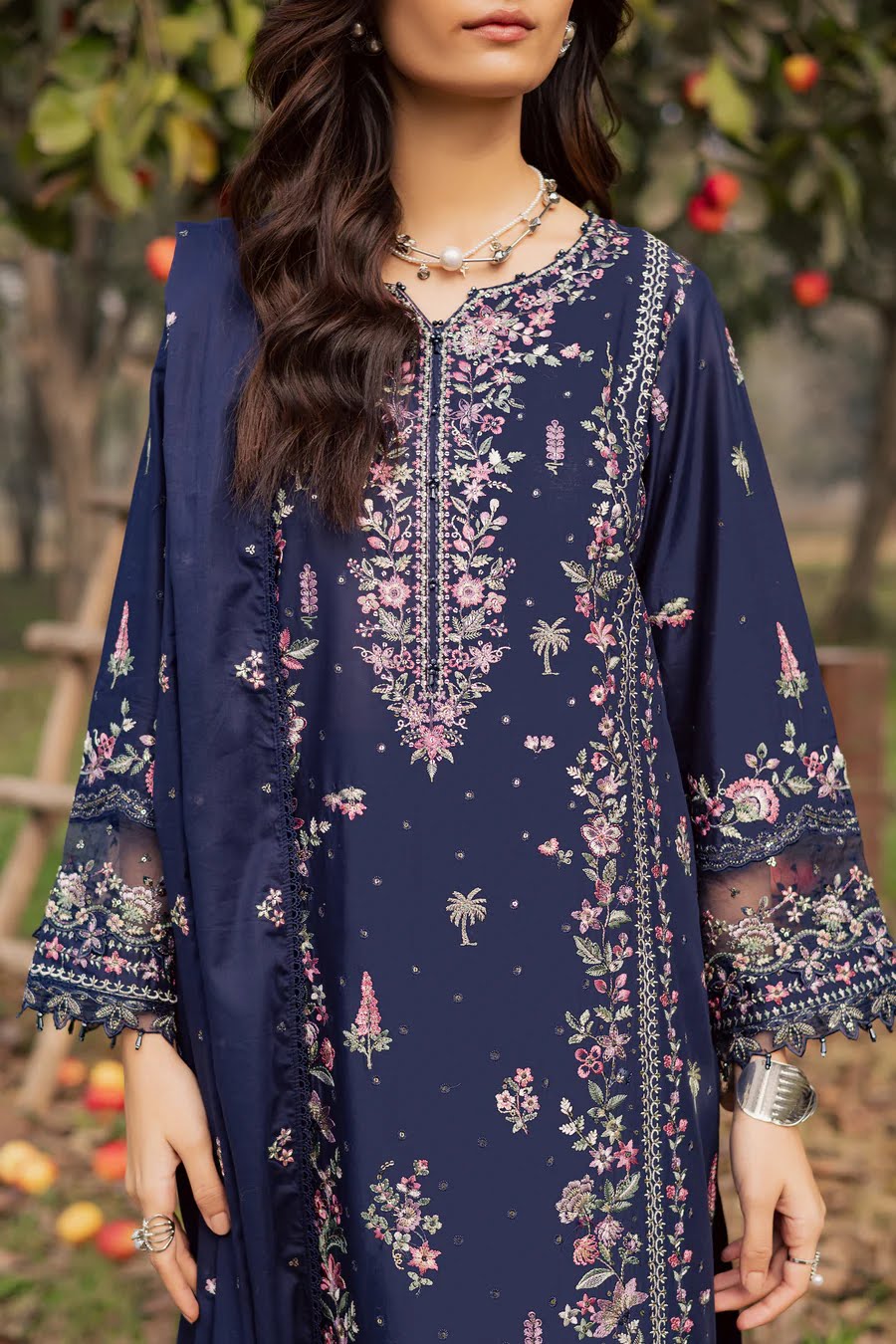 Woman wearing a navy blue floral dress with a blurred outdoor background