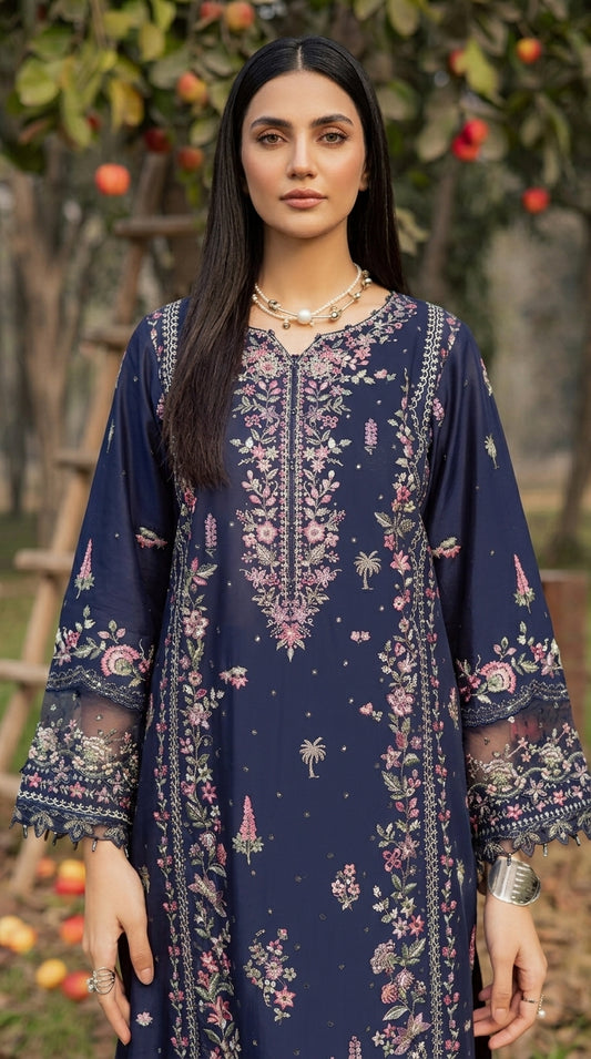 Woman wearing a navy blue embroidered dress with a floral pattern outdoors.