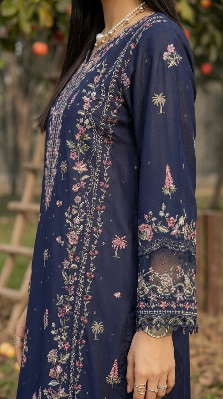 Navy blue dress with floral and palm tree patterns worn by a person, with a blurred natural background.