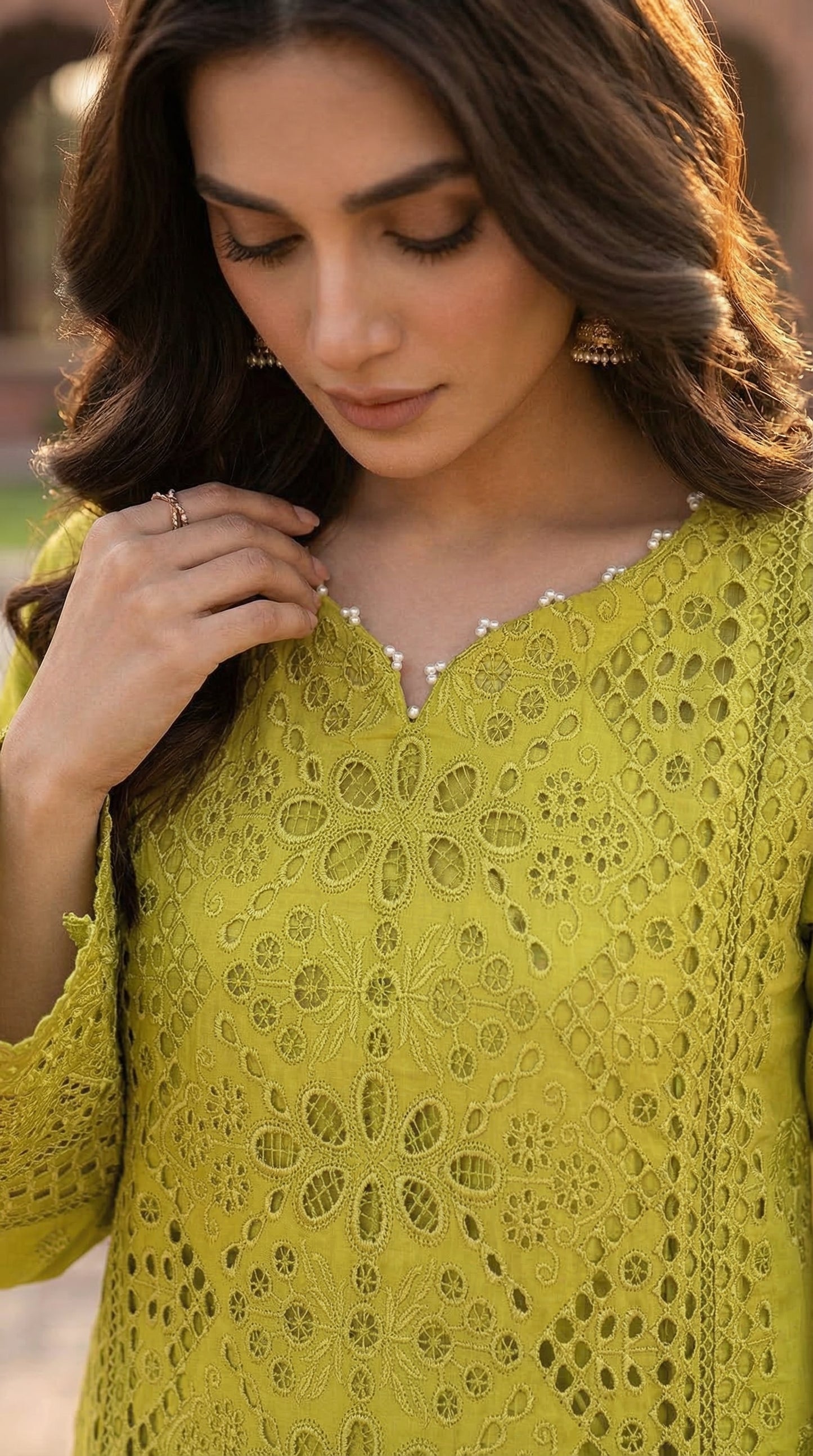 Woman wearing a green embroidered outfit with a blurred background