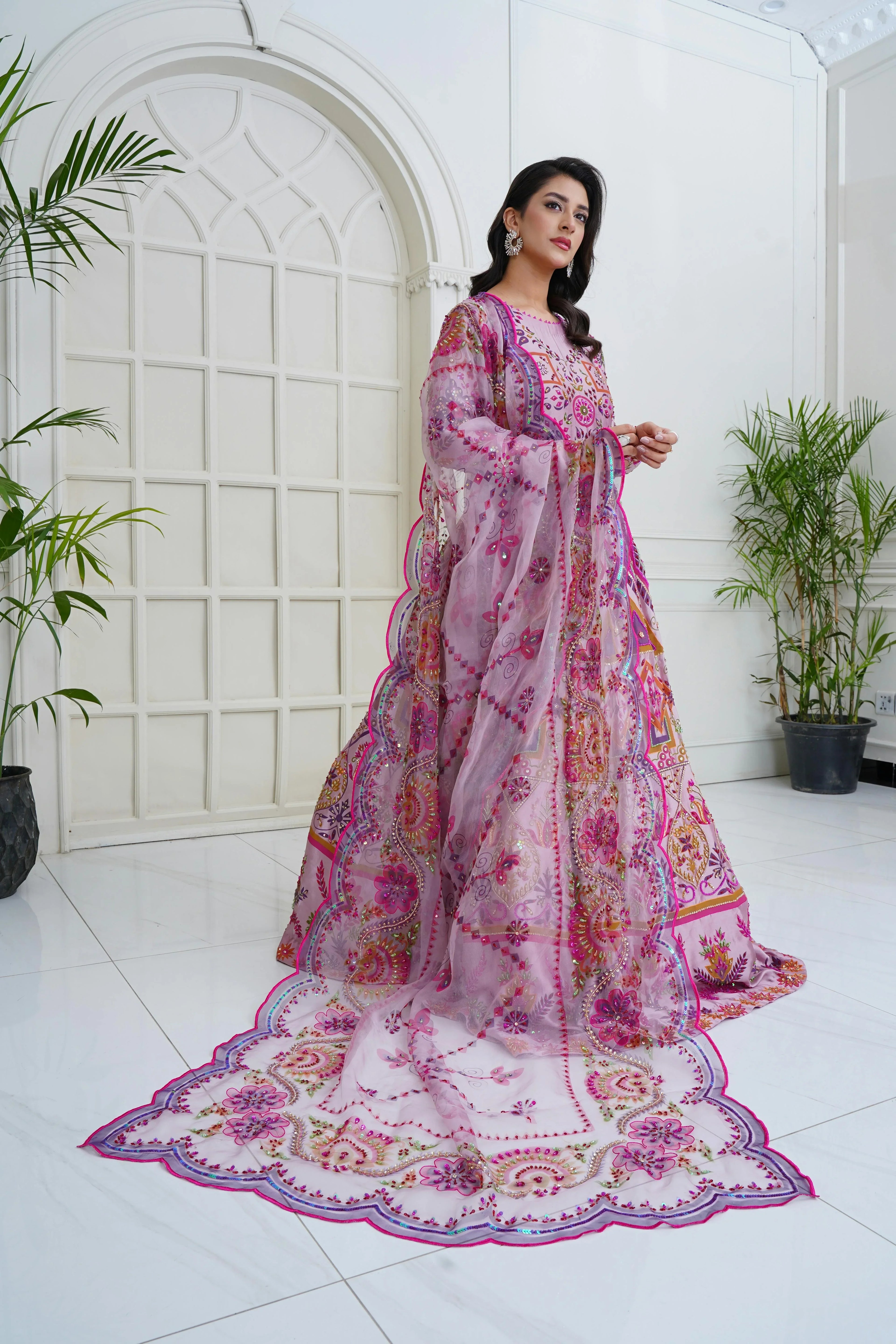 Woman in pink embroidered Pakistani formal wear, festive designer suit with floral details