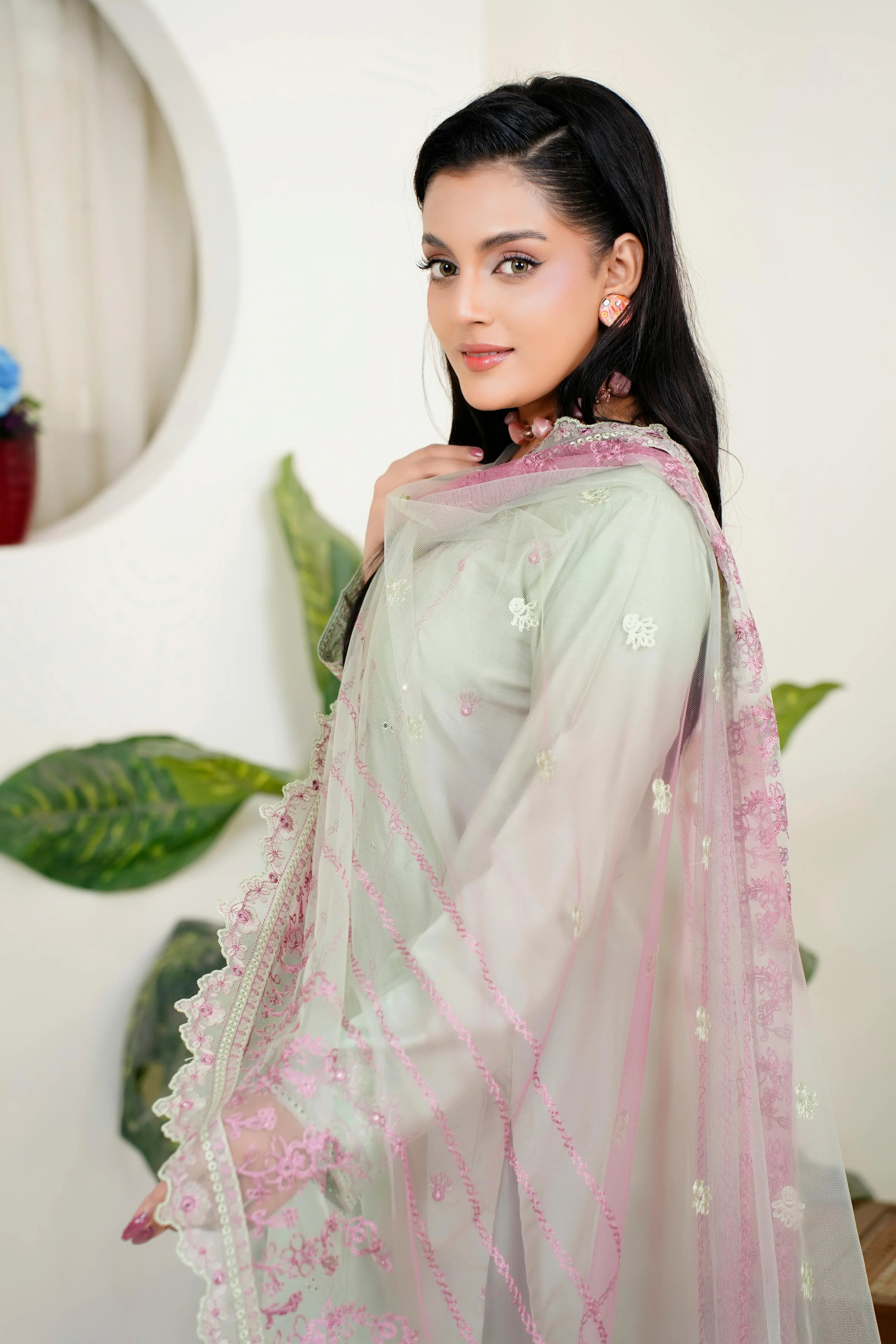 Woman in pastel embroidered Pakistani dress with pink dupatta, formal festive wear Pakistan